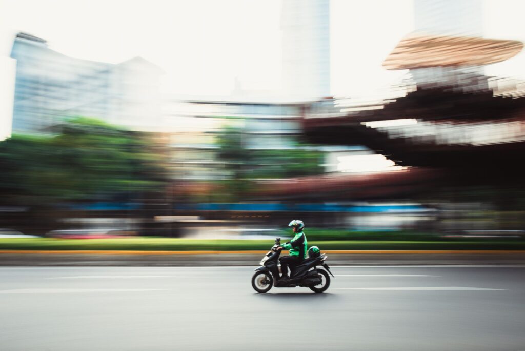 Dynamic panning shot of a motorcyclist speeding through city streets, showcasing urban motion.