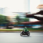 Dynamic panning shot of a motorcyclist speeding through city streets, showcasing urban motion.