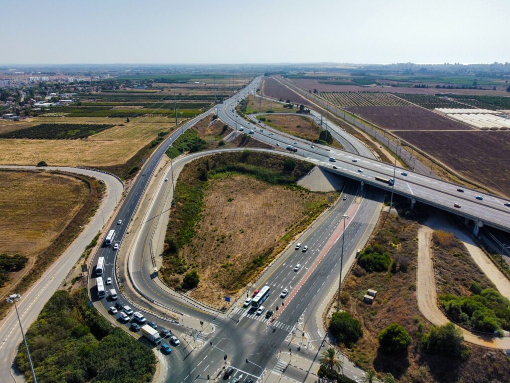 Aerial view capturing a busy highway intersection surrounded by agricultural fields and open landscape.
