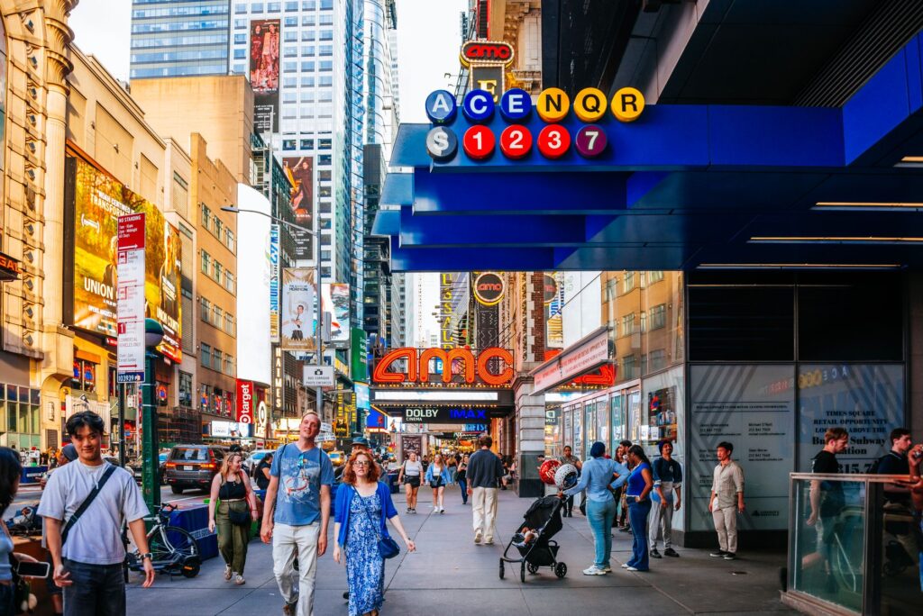 Bustling street in Times Square, NYC with diverse people and vibrant cityscape.