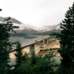 Breathtaking view of the Sylvenstein Dam bridge against misty mountains in Lenggries, Germany.