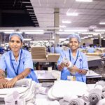 Two female textile workers sorting materials in a factory.