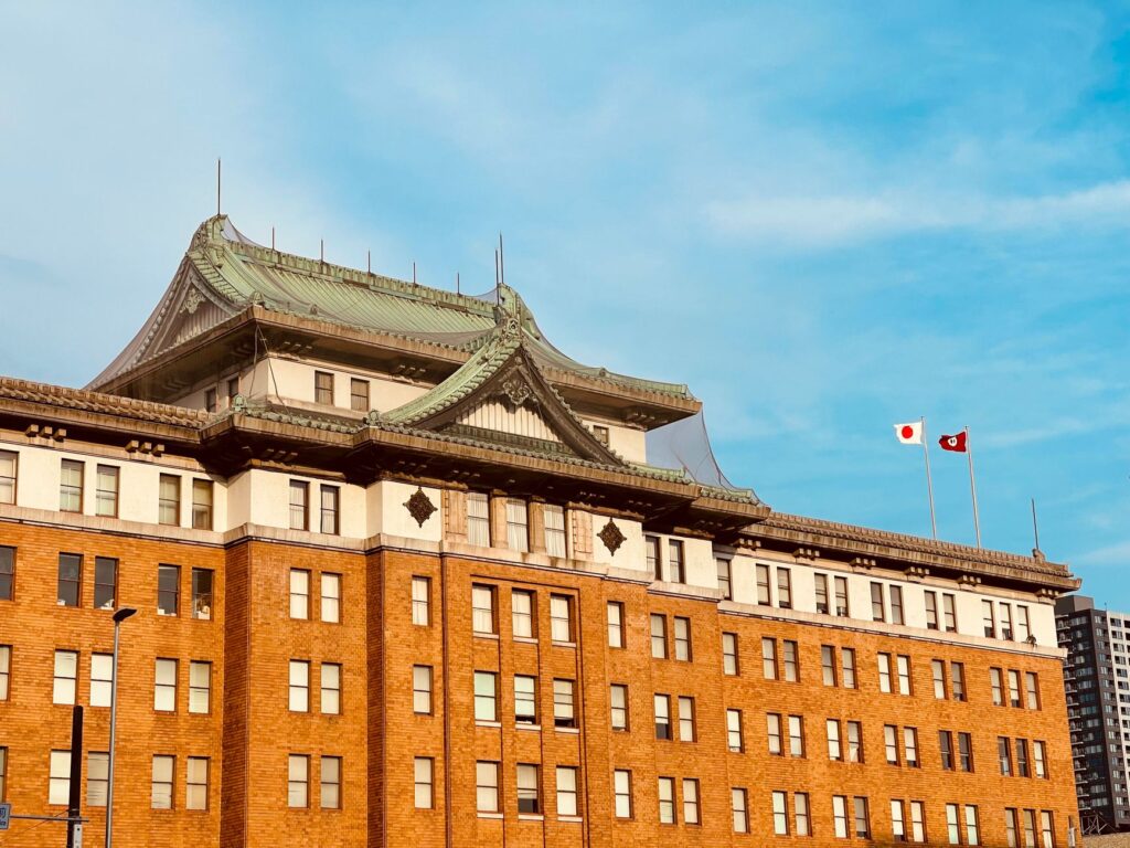 Historic government building facade in Nagoya showcasing imperial crown style architecture under a bright blue sky.