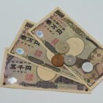 Close-up of Japanese Yen banknotes and coins arranged on a flat surface.