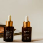 Liposomal and anti-dark circle serums showcased in stylish amber bottles with droppers.