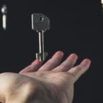 A mysterious scene of keys floating above an open hand against a dark background.