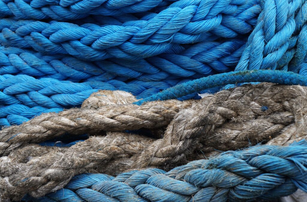 Detailed view of vibrant blue and rustic ropes, showcasing texture and contrast.