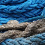 Detailed view of vibrant blue and rustic ropes, showcasing texture and contrast.