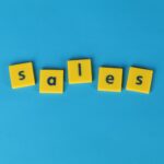 Yellow Scrabble tiles spelling 'sales' on a vibrant blue background. Perfect for marketing and business themes.
