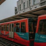 Red train at an urban station, signifying city travel and public transport.