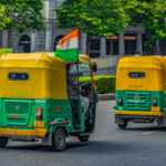 Auto rickshaws adorned with Indian flags driving through Connaught Place in New Delhi, India.