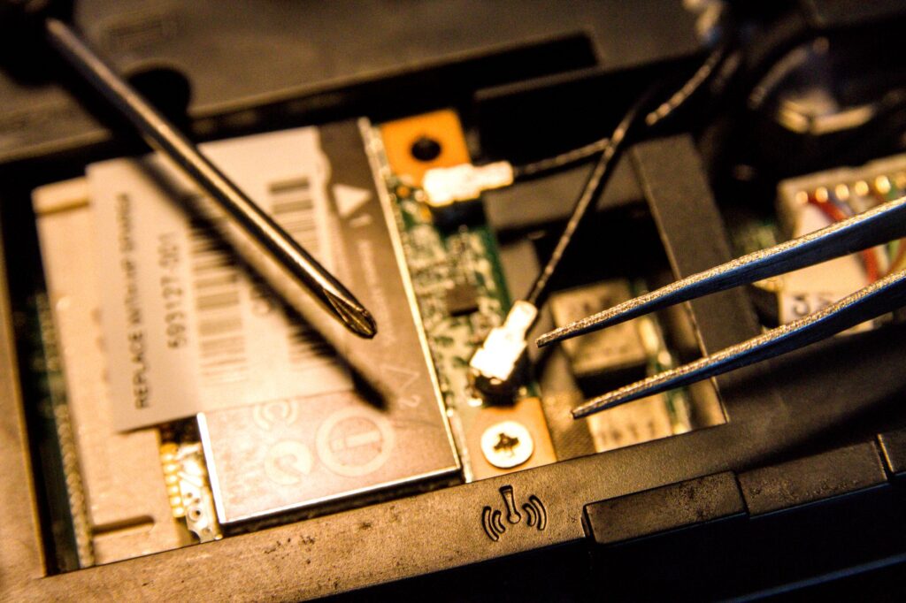 Detailed view of a laptop's internal parts being repaired with tools.