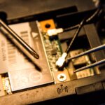 Detailed view of a laptop's internal parts being repaired with tools.