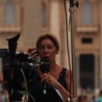 Journalist reporting live from Vatican City, capturing the essence of urban broadcast journalism.