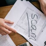 Documents highlighting tax fraud with the word 'scam' on tax forms.