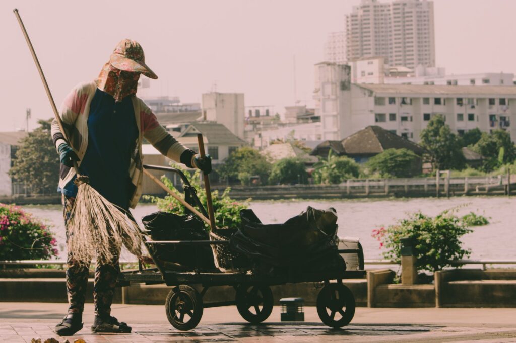 A hardworking woman cleaning the riverside in Bangkok, Thailand.