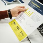 Person analyzing finance report with graphs at desk, ideal for business concepts.