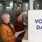 People voting indoors on election day, making decisions at a polling station.