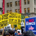 Vibrant protest with signs demanding rights and opposing deportations.