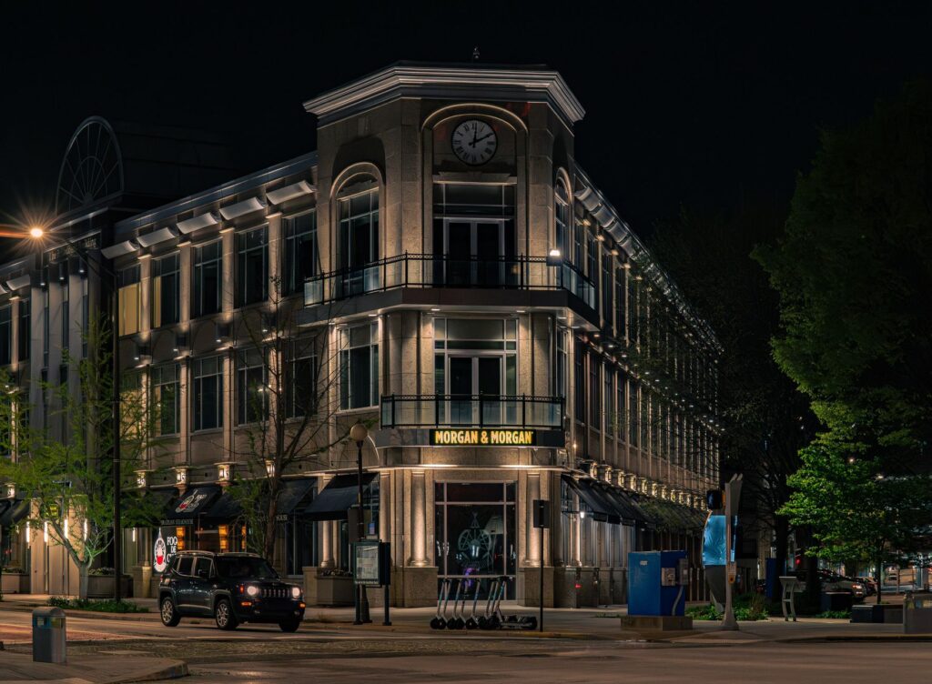 A beautifully illuminated historic building at night, featuring a prominent clock tower.