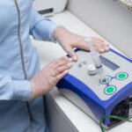 Close-up of a healthcare professional using a medical device in a clinical setting.
