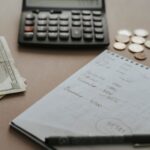Desk setup showing calculator, cash, coins, and financial notes for budgeting.