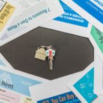 Overhead view of real estate brochures and house key, ideal for marketing.