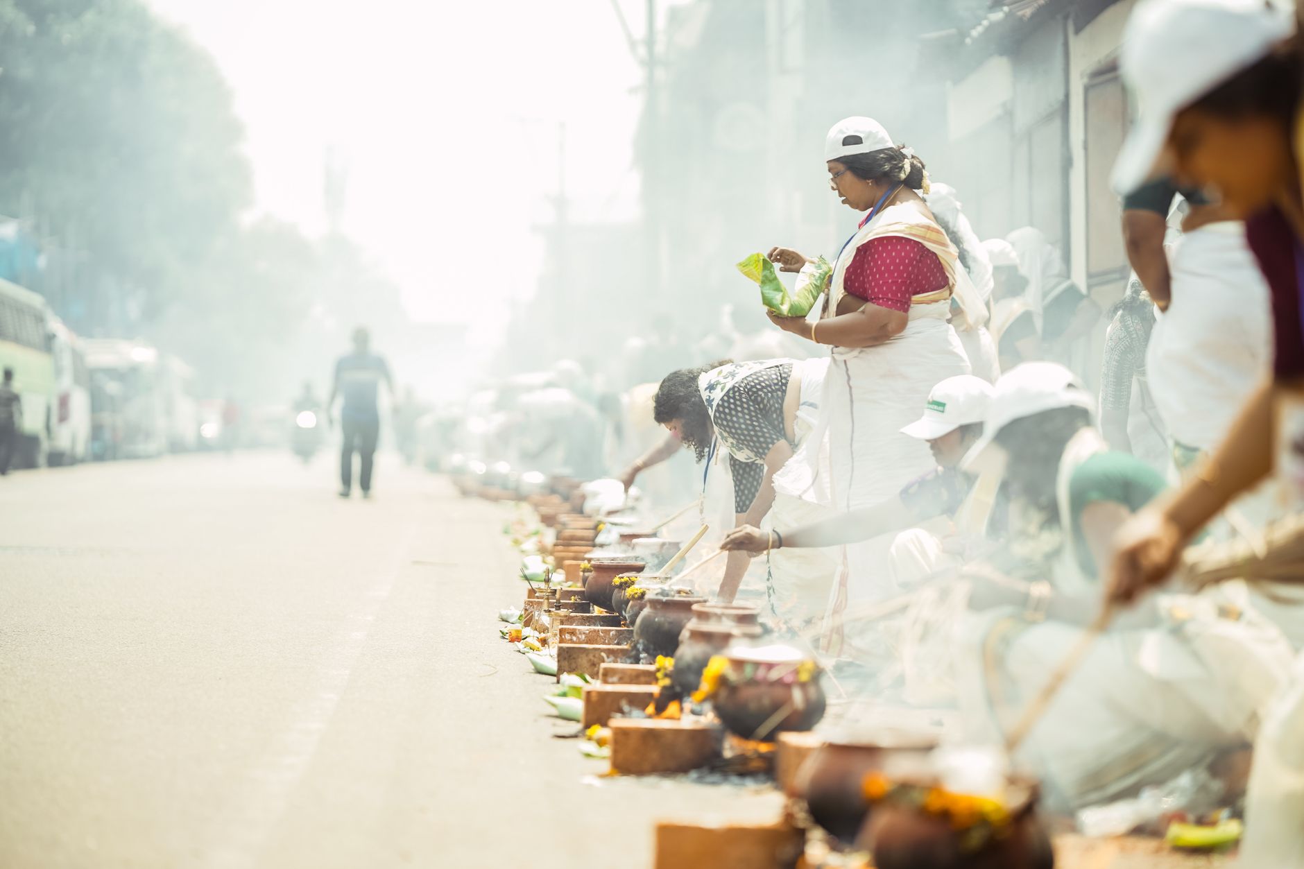 Women in traditional attire participate in outdoor cooking festival.