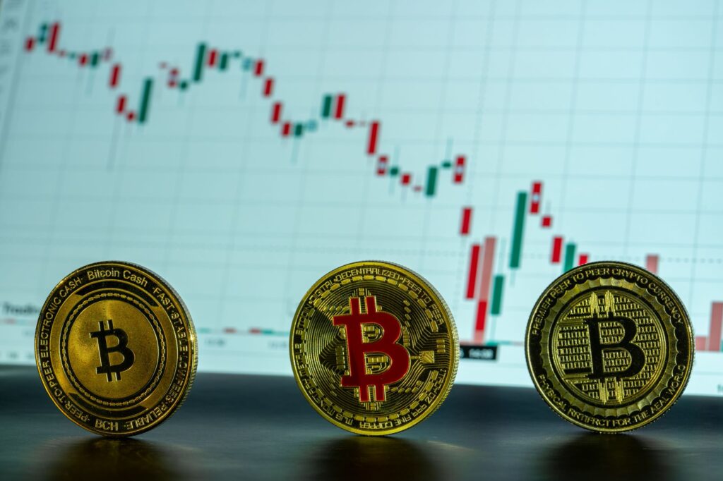 Bitcoin coins displayed in front of a financial market graph, illustrating cryptocurrency trends.