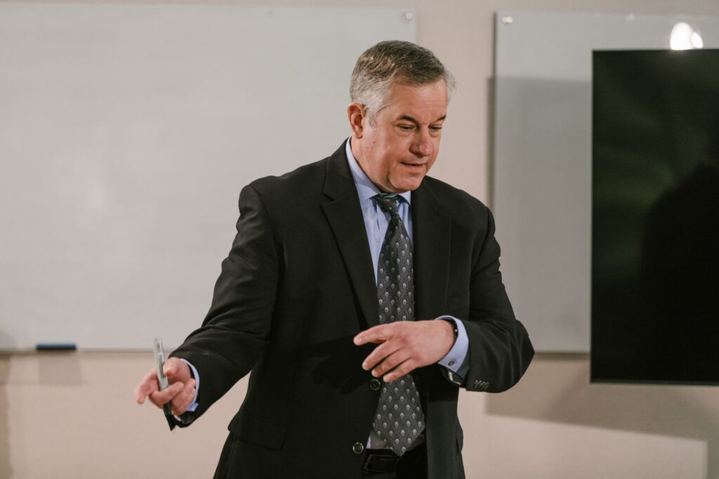 A business professional leading a presentation in a modern conference room.