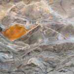 Detailed texture of a rugged rock surface with unique patterns and colors.