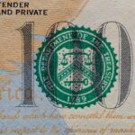 Detailed view of the US 100 dollar bill showing the Treasury seal and printed text.