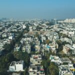 Aerial shot of Gurugram's urban landscape capturing dense residential buildings and city skyline.