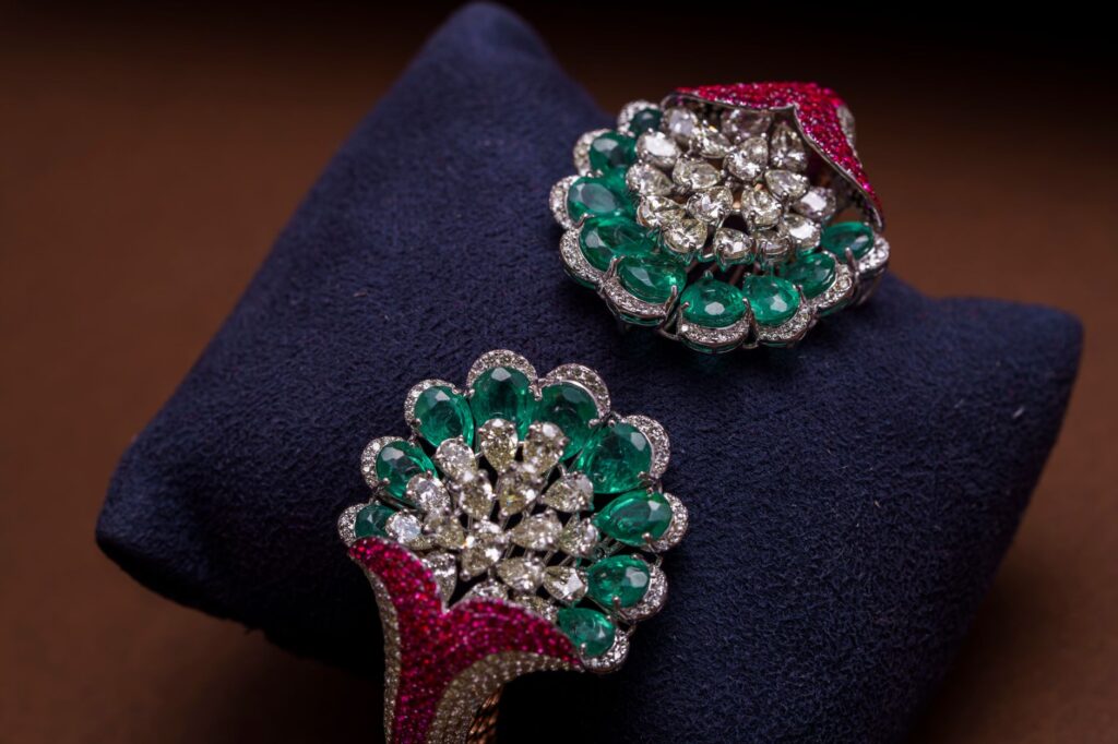 Exquisite emerald and diamond jewelry highlighting opulence on a rich dark background.