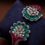 Exquisite emerald and diamond jewelry highlighting opulence on a rich dark background.