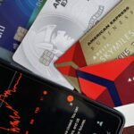 Image showing credit cards and a financial market graph on a smartphone.