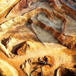 A striking aerial view of a large open-pit mine showcasing its excavation patterns.
