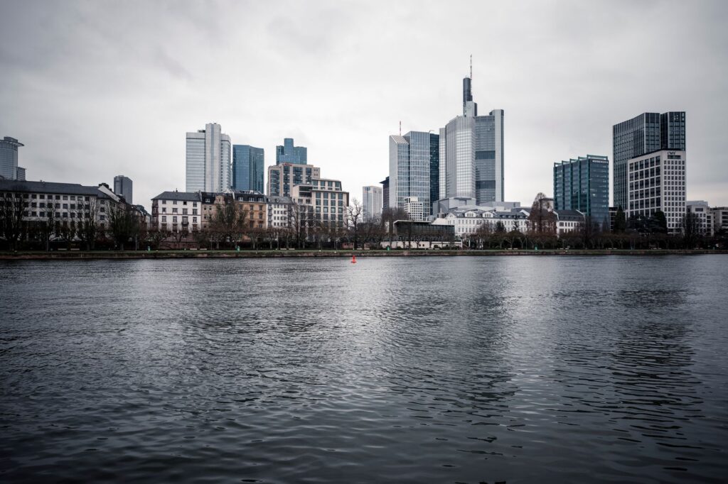 View of Frankfurt's skyline under an overcast sky across the river.