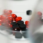 Red and black pills in a petri dish, ideal for healthcare and pharmaceutical themes.