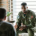 A group of military veterans participate in a supportive therapy session indoors.