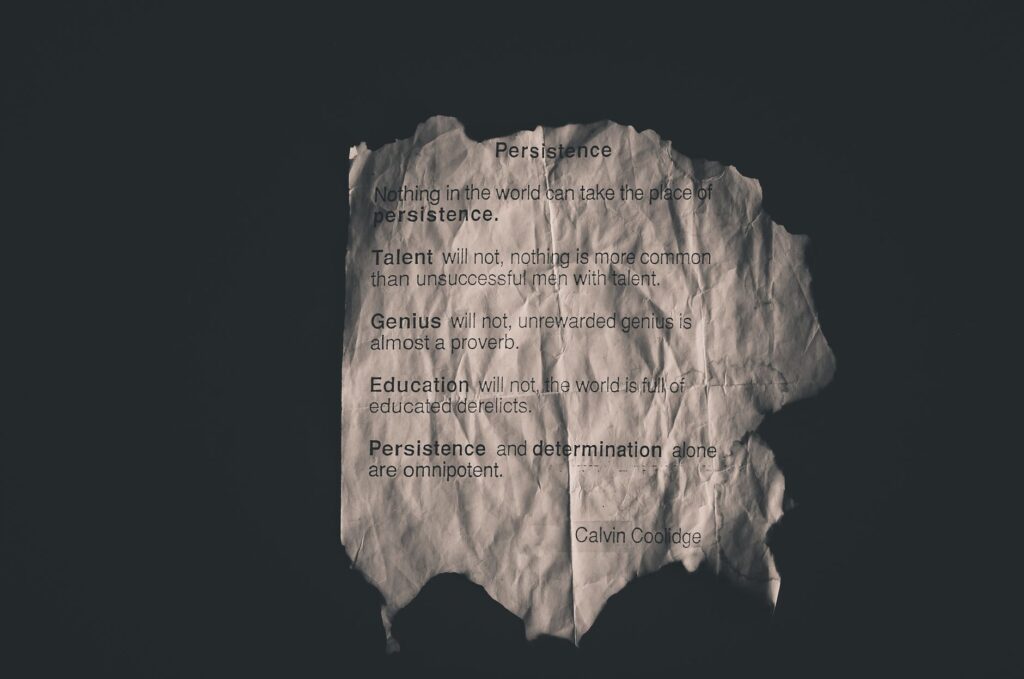 Calvin Coolidge quote on perseverance printed on crumpled paper.