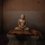 A tranquil marble statue in a dimly lit temple in Kanchipuram, India, exuding calmness.