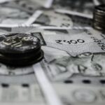 A detailed close-up of Indian currency notes and coins, highlighting financial themes.