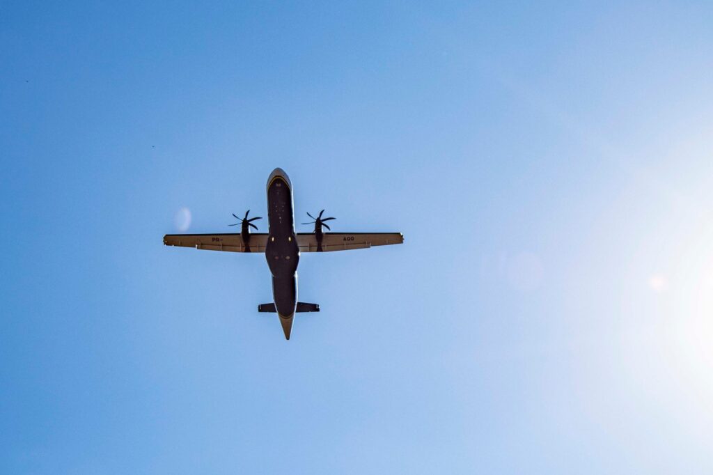 A dramatic view of an airplane flying overhead against a clear blue sky in Londrina, Brazil.