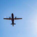 A dramatic view of an airplane flying overhead against a clear blue sky in Londrina, Brazil.