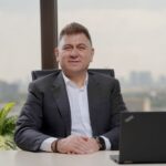Confident middle-aged businessman in an elegant office with city view.