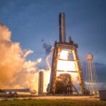 A dramatic shot of a SpaceX rocket launch against a colorful dusk sky, depicting power and technology.