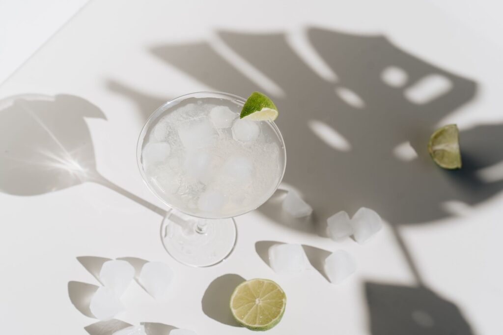 A cool margarita with ice cubes and lime, evoking a refreshing summer vibe.