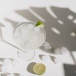 A cool margarita with ice cubes and lime, evoking a refreshing summer vibe.