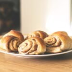 Warm and inviting cinnamon rolls on a white plate, perfect for a sweet treat.